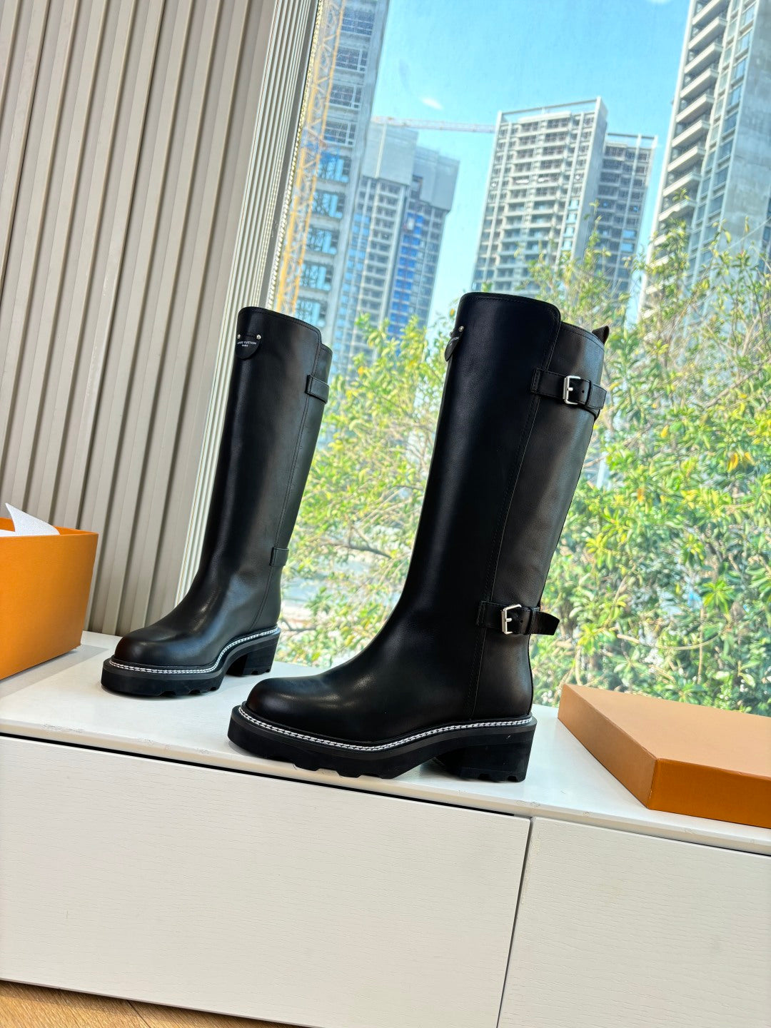 Black knee-high leather boots with two buckle straps and low heel