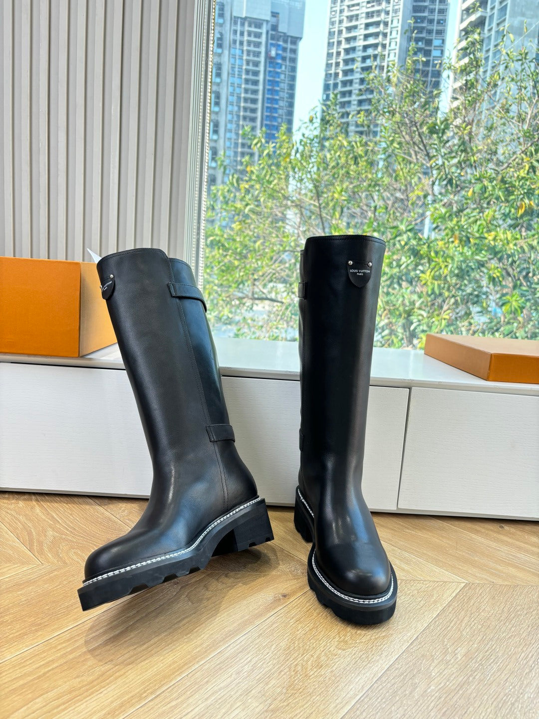 Black leather knee-high boots with wide side panels and chunky sole