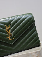 Green leather clutch flap with YSL gold-tone logo and quilted chevron stitching.