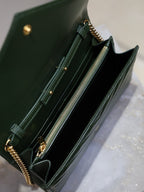 Green quilted leather clutch interior with zipper detail and gold-tone hardware, chain visible.
