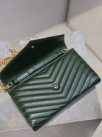 Green quilted leather clutch opened with black interior lining, snap closure, and YSL logo.