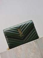 Quilted green leather clutch with YSL logo and gold-tone chain strap, angled side view.