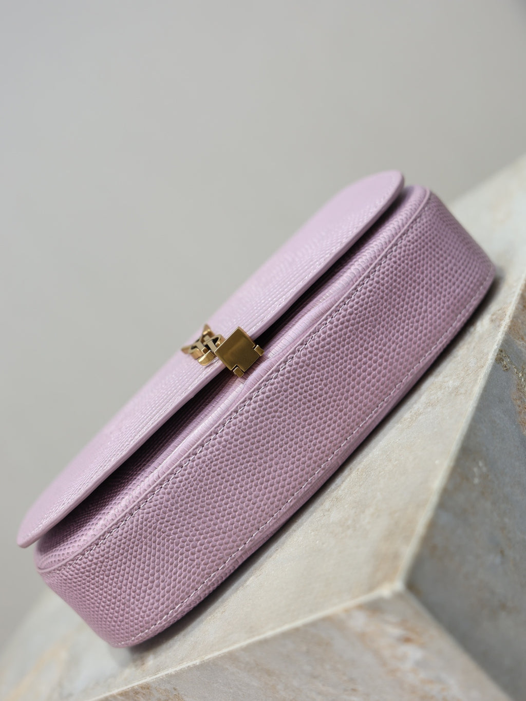 YSL small pink bag side profile with flap closure and gold-tone clasp hardware