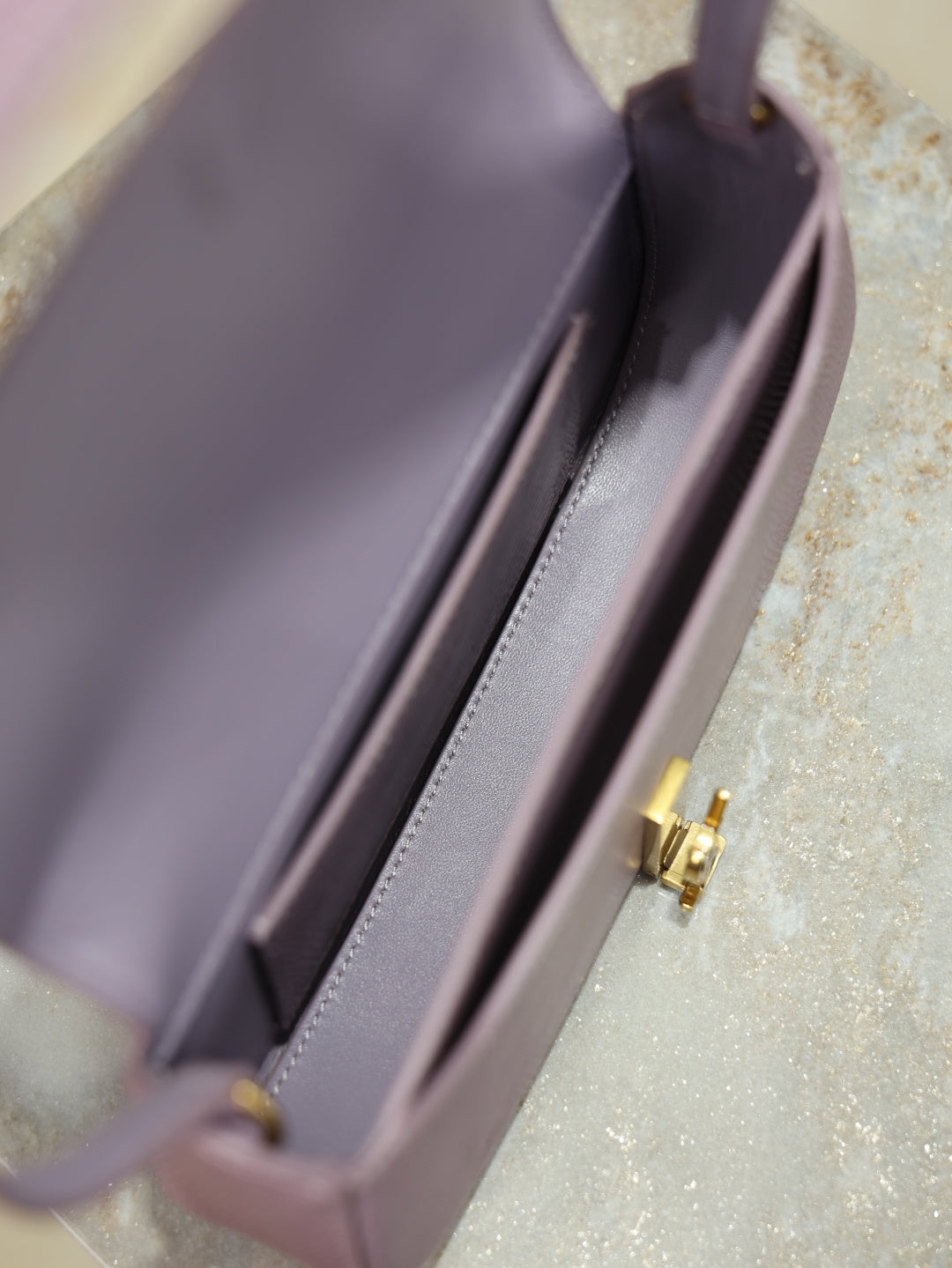 YSL small bag interior view with side wall and gold-tone logo clasp hardware