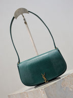 Teal leather handbag with curved top handle, side view with gold YSL logo