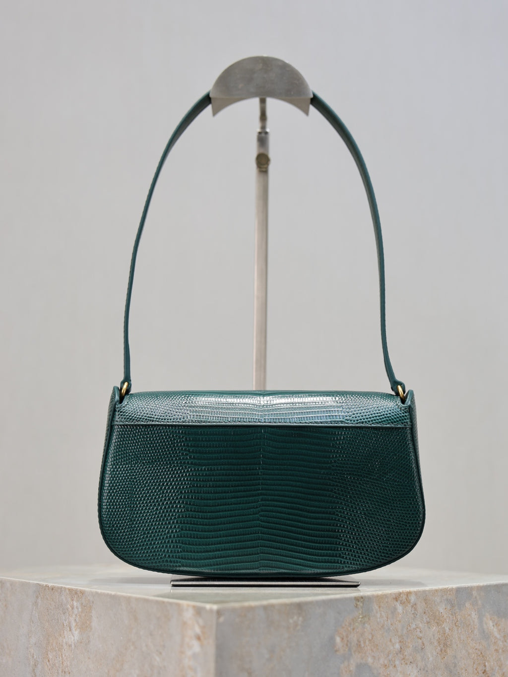 Teal leather handbag front view with curved top handle and gold YSL logo