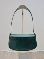 Teal leather handbag front view with curved top handle and gold YSL logo