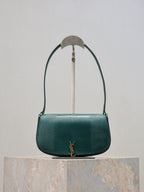 Teal leather handbag with curved top handle, gold YSL logo front, flap closure