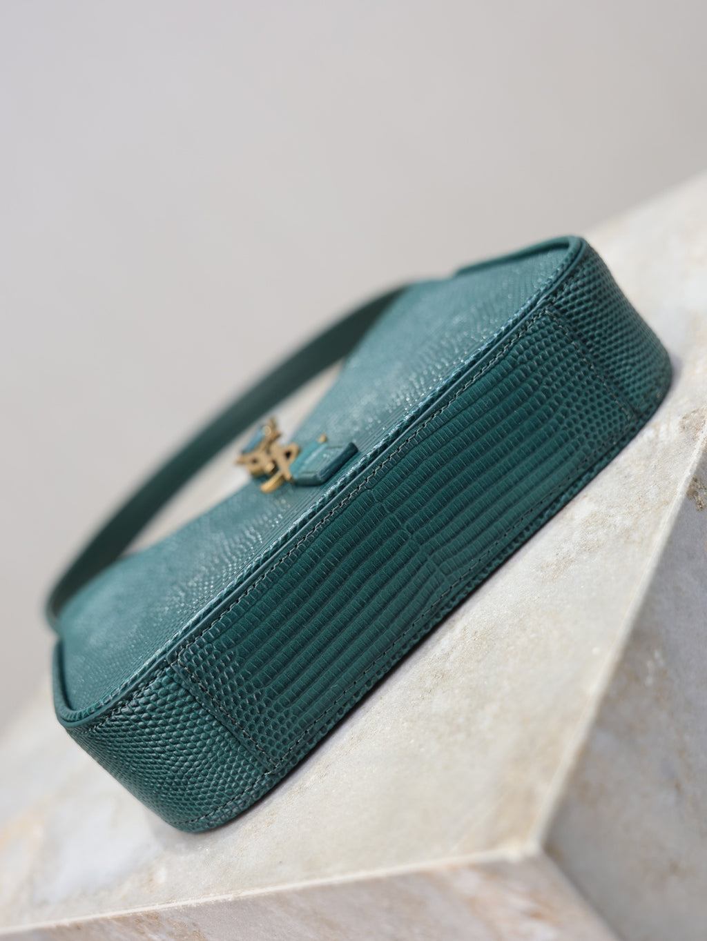 YSL small handbag back view in teal textured leather, top handle, gold YSL logo tab.