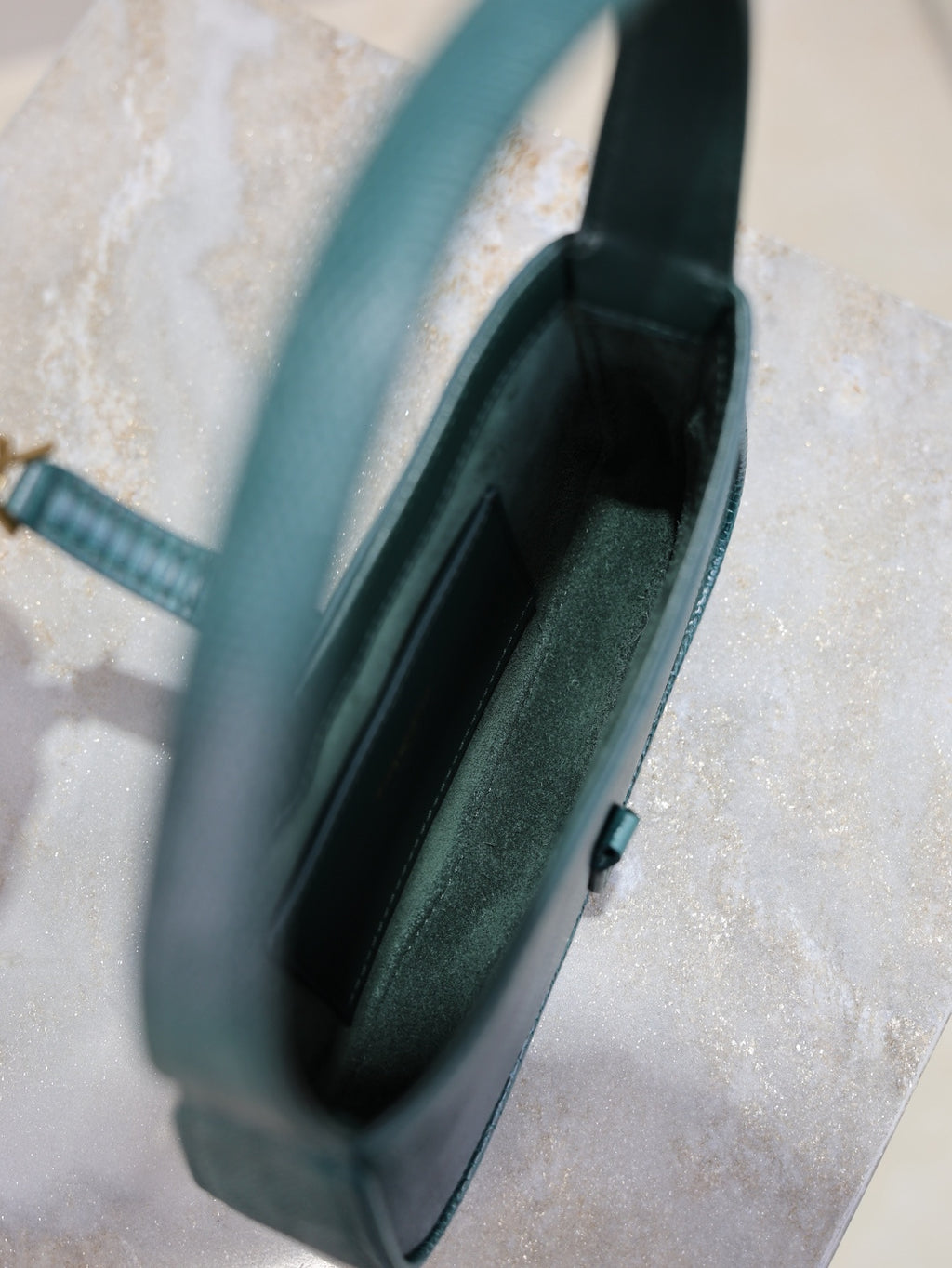 YSL small handbag interior view, teal textured exterior, open top with slim clasp.