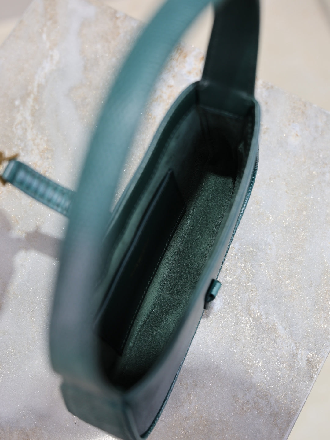 YSL small handbag interior view, teal textured exterior, open top with slim clasp.