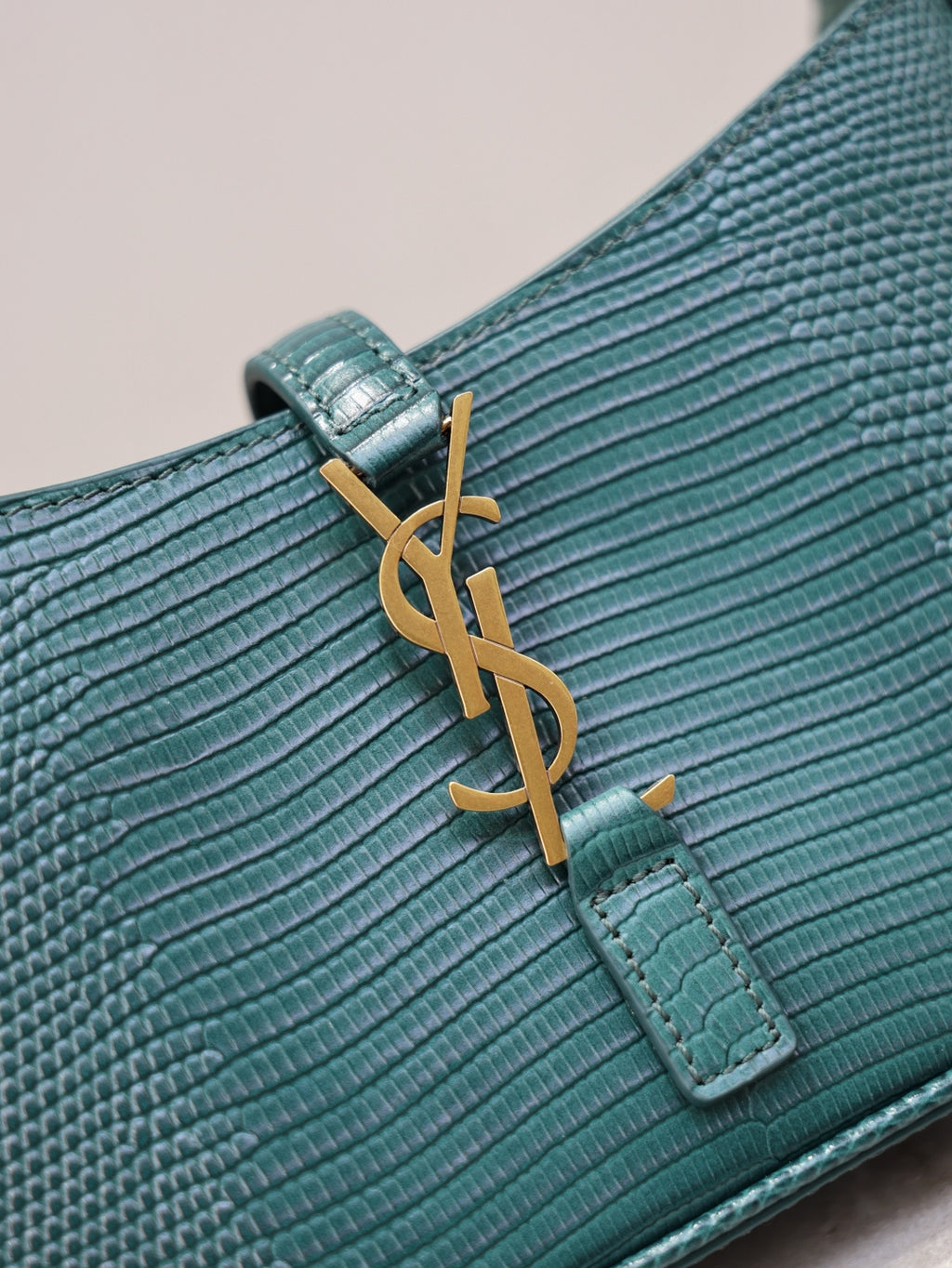 YSL small handbag logo detail on teal textured leather with gold YSL hardware and tab.
