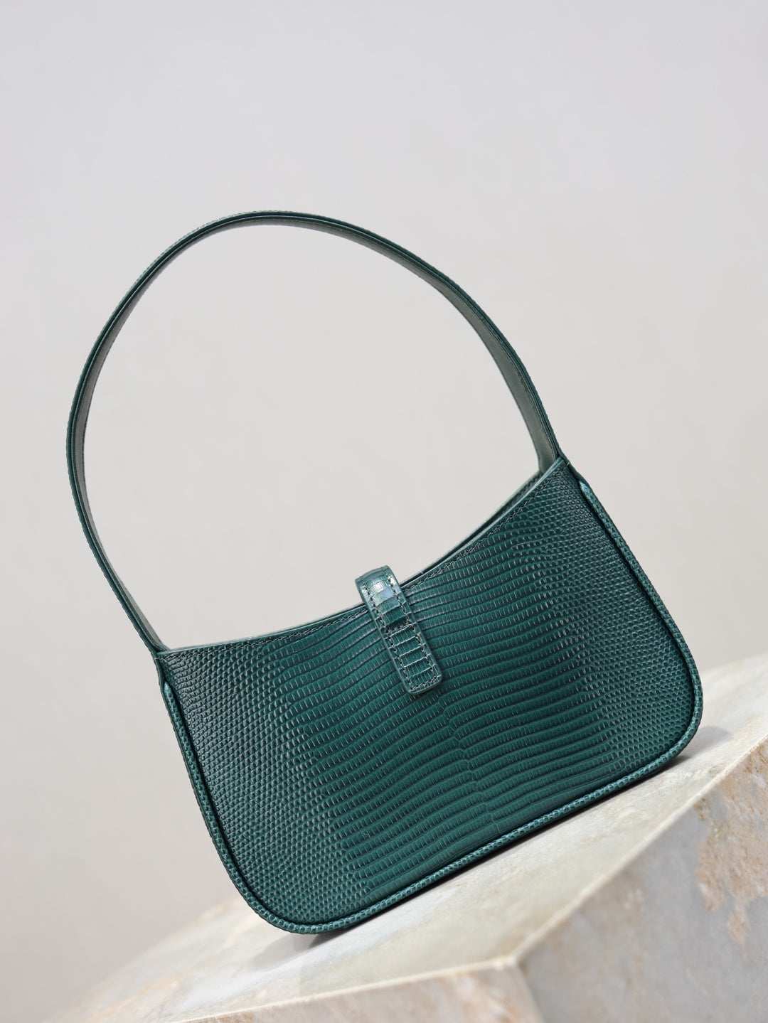 YSL small handbag front view in dark teal textured leather, rounded handle, gold YSL hardware.