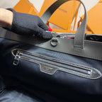 Men’s Louis Vuitton bag front close-up with zipper pocket and logo patch.