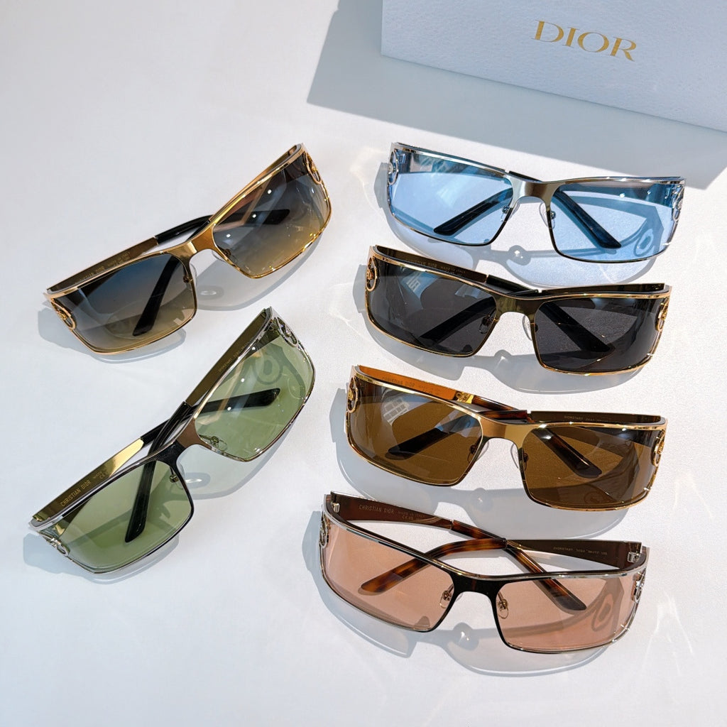 Assorted sunglasses with tinted lenses and gold frames arranged together.