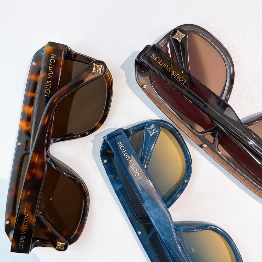 Assorted sunglasses on display: tortoiseshell, blue, and dark frames with tinted lenses.