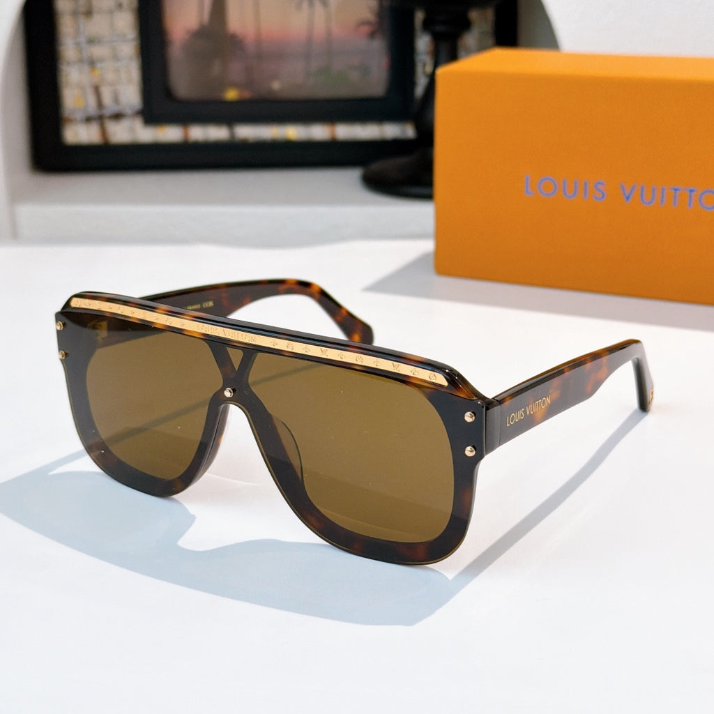 Sunglasses with tortoiseshell frames and amber-brown tinted lenses, gold-tone trim.
