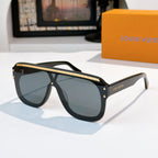 Sunglasses with black frames and dark green tinted lenses, gold-tone trim on temples.
