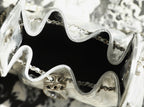 Silver handbag interior close-up with black lining and chain hardware