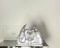 Silver metallic drawstring handbag with quilted body and chain shoulder straps