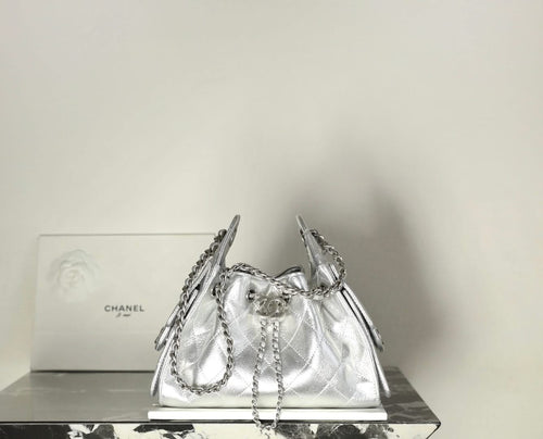 Silver metallic drawstring handbag with quilted body and chain shoulder straps