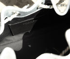Black interior label on a silver handbag, with visible brand tag text