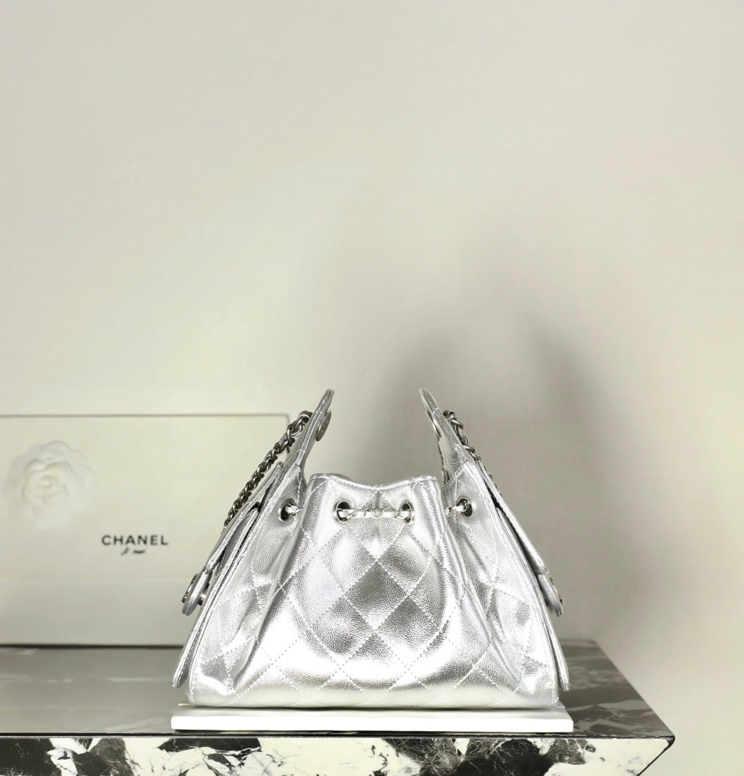 Silver metallic drawstring handbag with diamond quilting and chain shoulder straps
