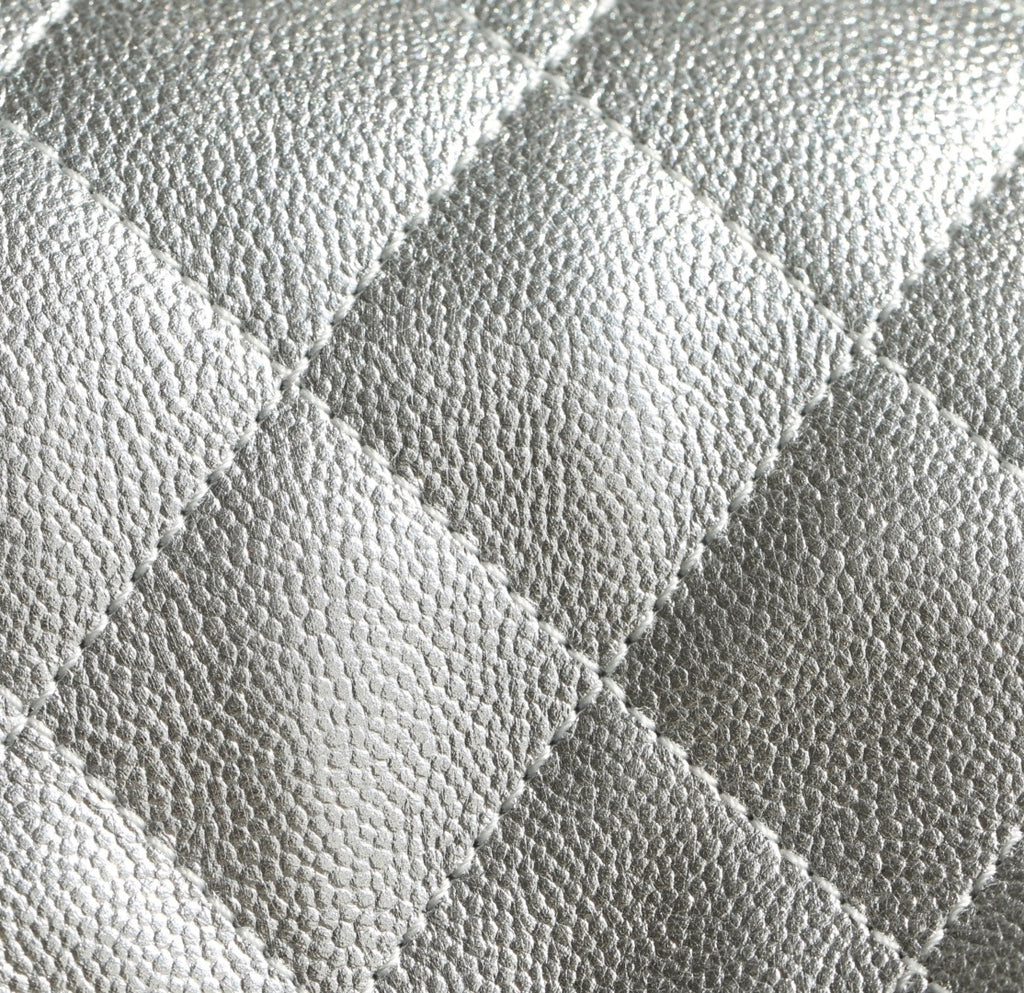 Silver quilted handbag leather texture close-up with diamond stitching