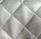 Silver quilted handbag leather texture close-up with diamond stitching