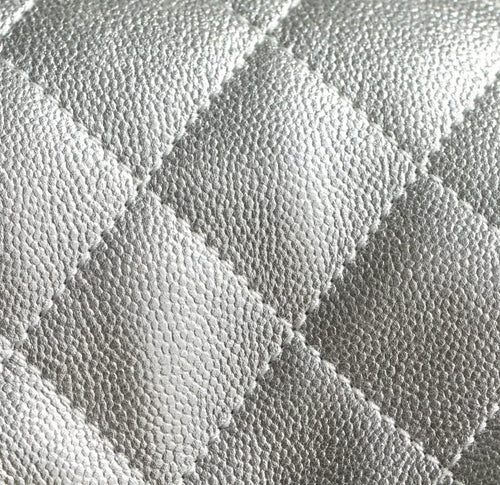 Silver quilted handbag leather texture close-up with diamond stitching