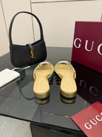 Gucci gold slide sandals with jeweled GG logo, side view