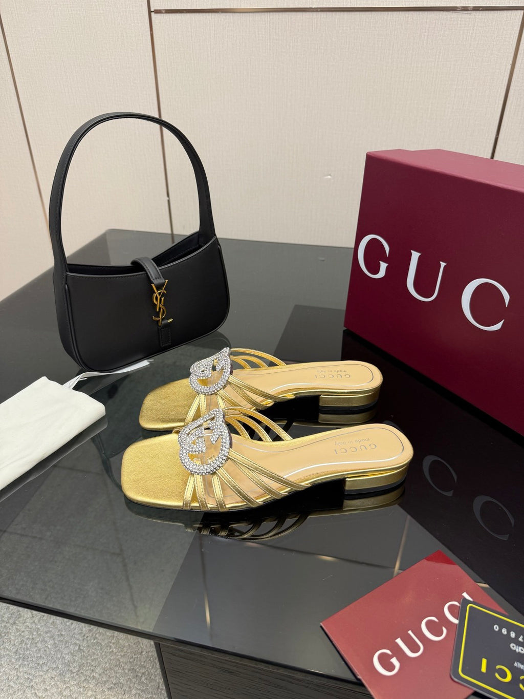 Gucci gold slide sandals with jeweled GG logo detail and low heel