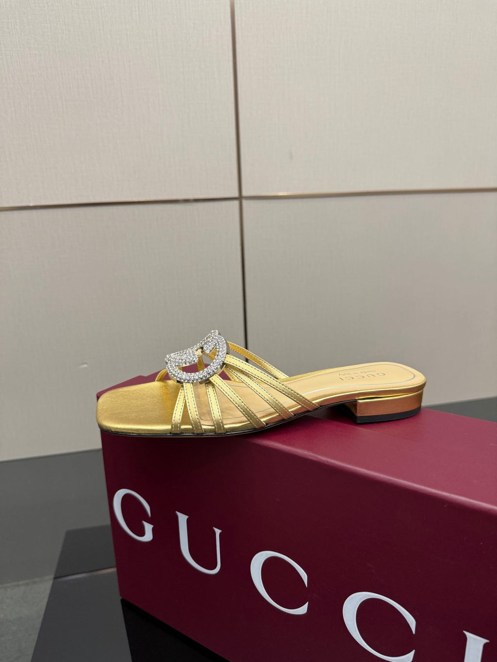 Gucci gold slide mule sandals with jeweled GG logo, front angle
