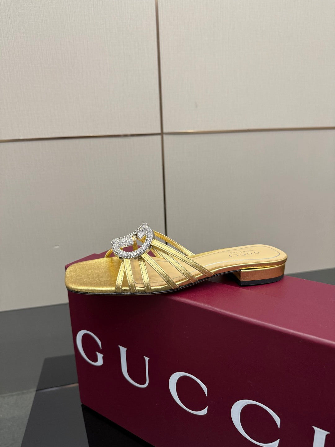 Gucci gold slide mule sandals with jeweled GG logo, front angle
