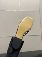 Gucci ladies black mule sandal outsole and yellow footbed held in hand