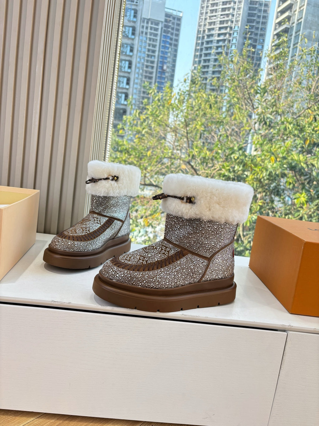 Pair of brown glitter ankle boots with white fur cuffs and moc-style straps
