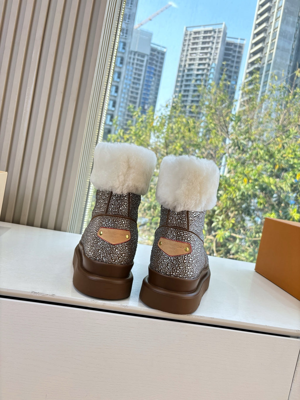 Brown glitter ankle boots with plush white cuffs and small tan patch on back
