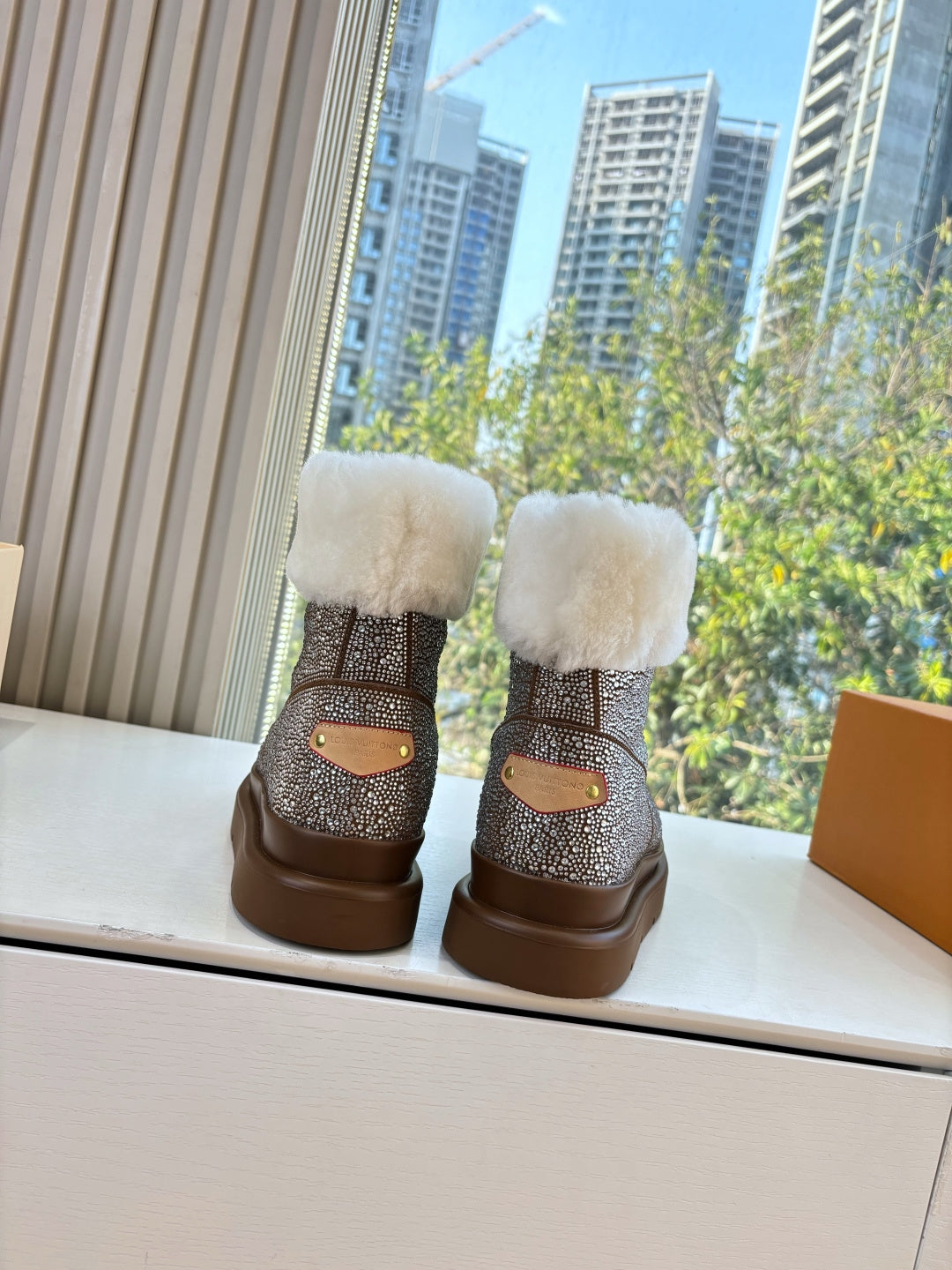 Brown glitter ankle boots with plush white cuffs and small tan patch on back