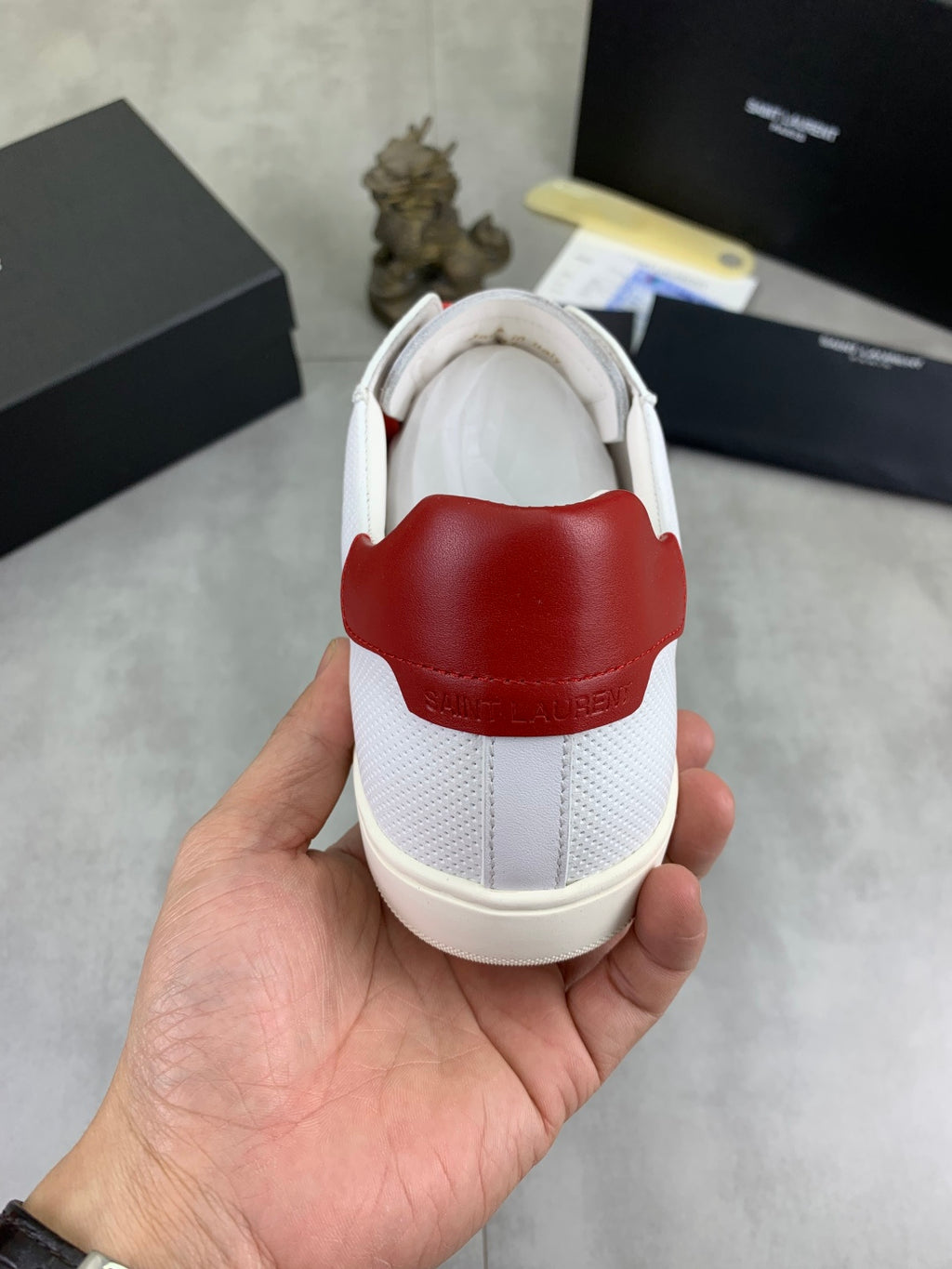 White low-top sneaker heel with red rubber insert and cream sole.