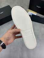 White sneaker outsole with textured grip tread, held in hand.