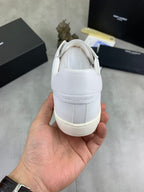 White lace-up sneaker heel with embossed logo and padded collar