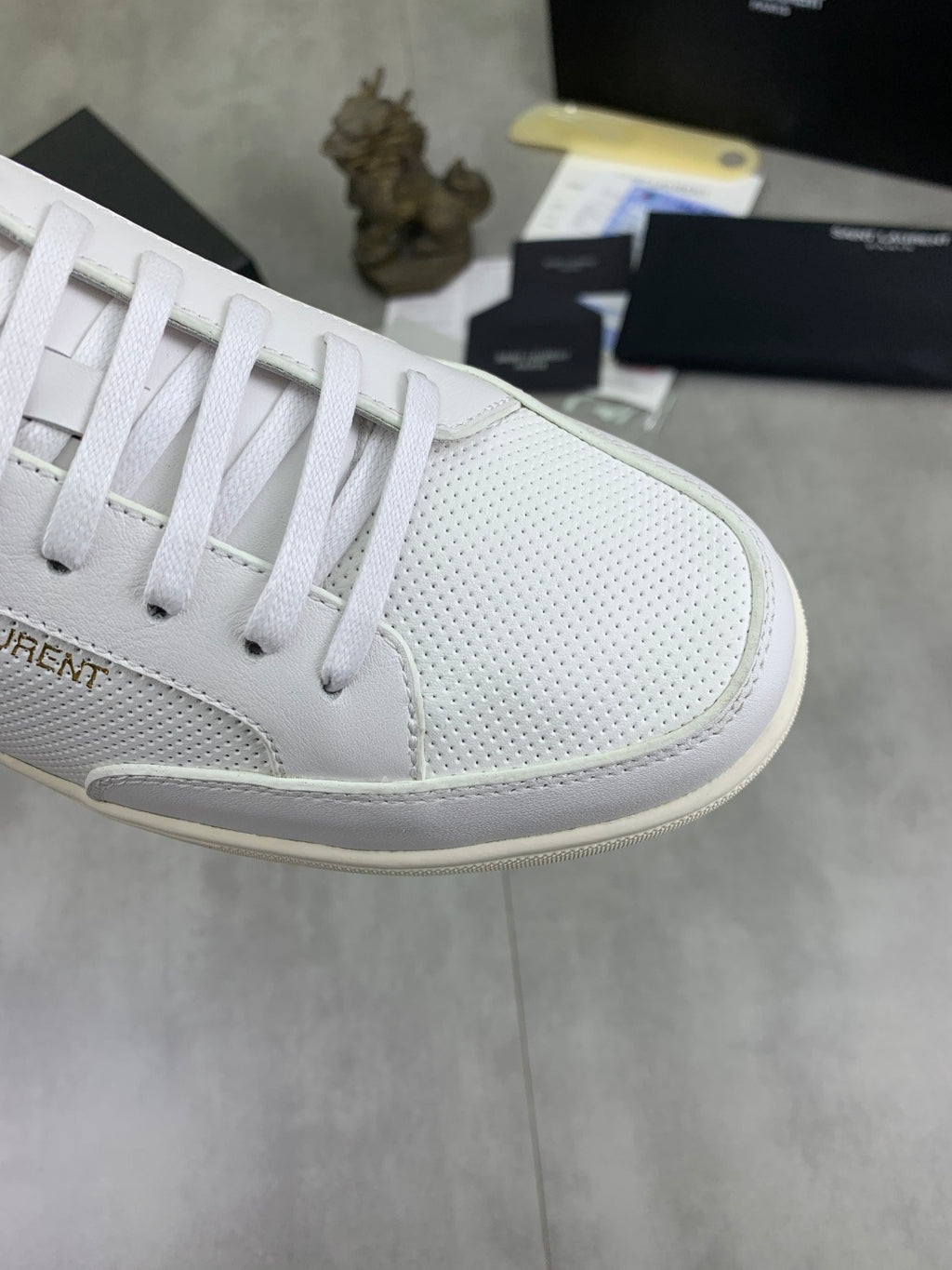 White perforated sneaker toe with lace-up eyelets and rubber midsole