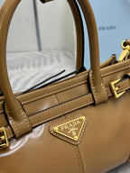 Tan leather tote bag with interior pocket view and Prada logo plaque on front