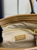 Tan leather zipper pocket with Prada Made in Italy logo plaque and gold zipper pull