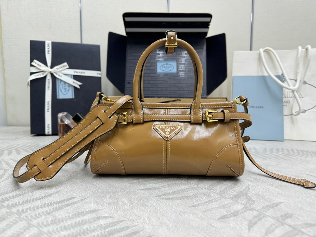 Tan leather tote bag with gold hardware, top handle, and detachable shoulder strap