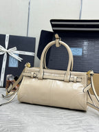 Cream leather Prada handbag with structured top, curved handle, and gold-tone hardware