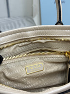Cream leather Prada mini bag interior with lined pattern and gold-tone zipper pull