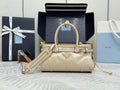 Cream leather Prada handbag with top handle, front buckle details, and adjustable strap