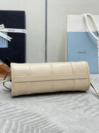 Cream leather Prada clutch-style handbag with flap front and gold-tone zipper track