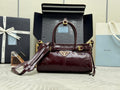 Burgundy leather handbag with top handle, gold-tone hardware, and strap attachments.